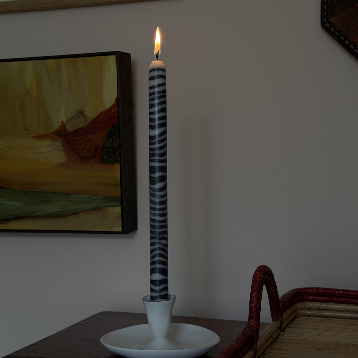 Shilling sculptural dinner candle by Pygmalion London, lit in a white candlestick