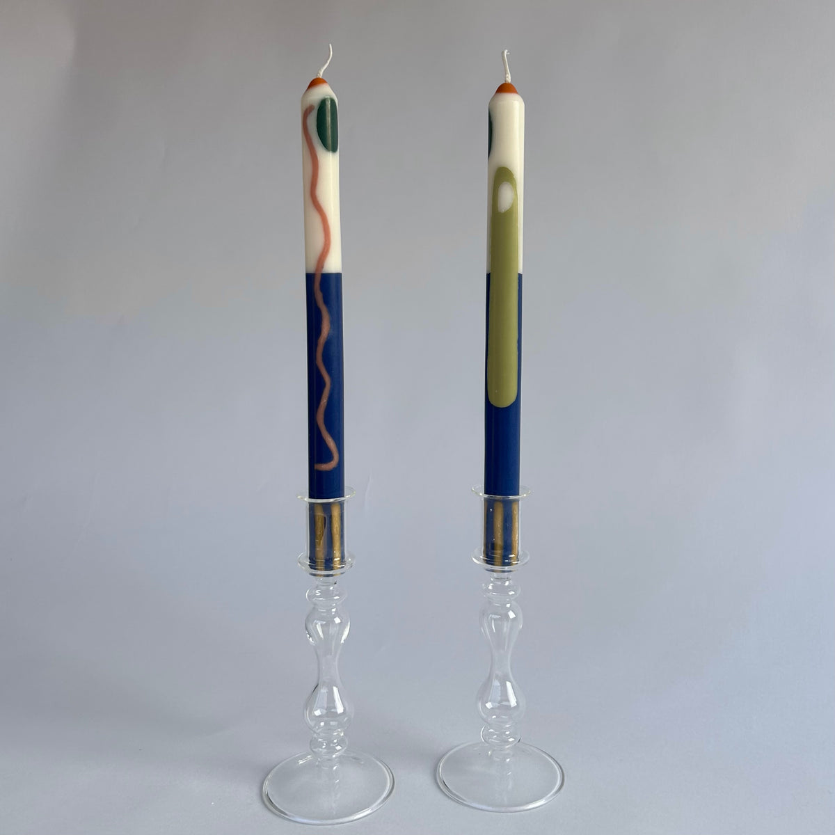 Terracotta patterned dinner candles by Pygmalion London, a hand-poured pair in blue, burnt orange, ochre, mustard yellow, racing green and red